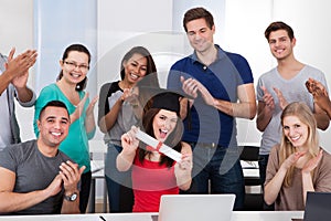 Students Clapping For Classmate Holding Degree