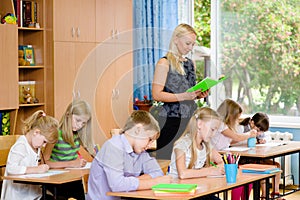 Students in the class write assignments that reads them a young photo