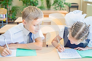 Students or classmates in school classroom sitting together at desk