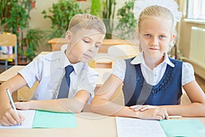 Students or classmates in school classroom sitting together at desk