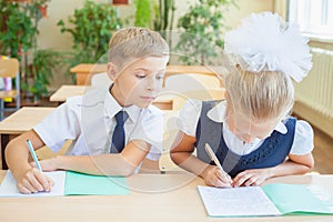 Students or classmates in school classroom sitting together at desk