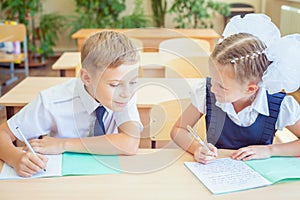 Students or classmates in school classroom sitting together at desk