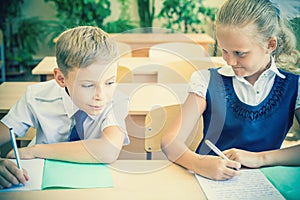 Students or classmates in school classroom sitting together at desk