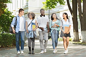 Students communication. Group of college friends walking outdoors in university campus