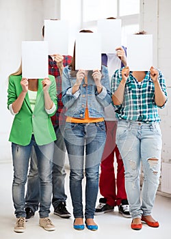 Students covering faces with blank papers