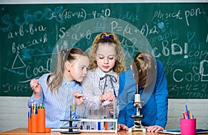 Students doing biology experiments with microscope. Little kids learning chemistry in school lab. Chemistry microscope