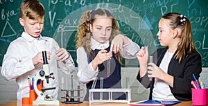 Students doing experiments with microscope. Happy children. Chemistry lesson. Little kids learning chemistry in school