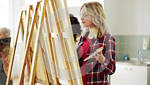 Students with easels painting at art school