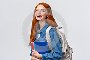 Students, education and studying concept. Lovely charismatic redhead foxy girl with backpack, notebooks and study books