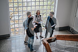 Students engaging in discussion with professor in university hall