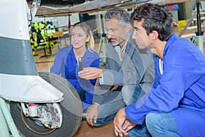 Students examining aircraft`s landing gear