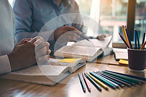 Students are explaining about assignments related to student homework to friends in the library at the university
