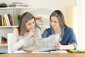 Students finding suspicious news in a newspaper photo
