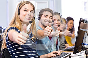 Students gesturing thumbs up in computer class