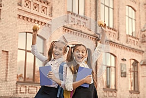 Students girls classmates with backpacks having school lunch, child care concept