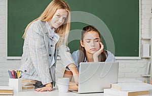 Students girls friends in classroom at school college or university. Two students doing homework together and helping