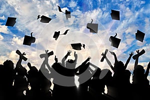 Students graduate cap throwing in sky