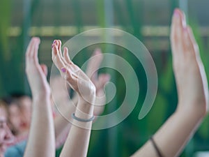 Students group raise hands up on class