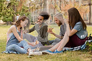 Students having picinic on grass in front of university.