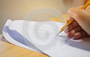 Students holding pen in hands taking exams, writing examination