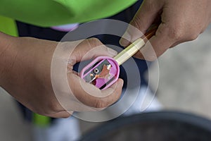 Students holding sharpeners to sharpen the Colored pencil.