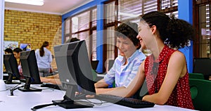 Students interacting with each other while using computer