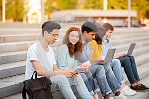 Students Learning Preparing For Exams Sitting On College Steps Outdoor