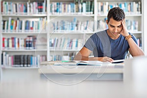 Students in a library - handsome student reading a book