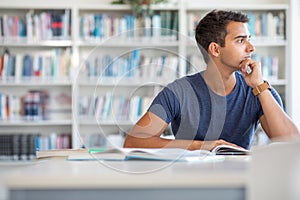 Students in a library - handsome student reading a book