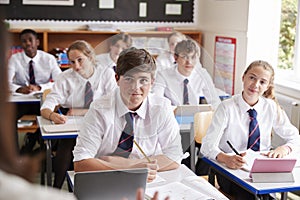 Students Listening To Female Teacher In Classroom