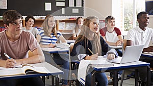 Students Listening To Female Teacher In Classroom