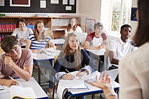 Students Listening To Female Teacher In Classroom