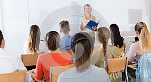 Students listening to lecture of female teacher