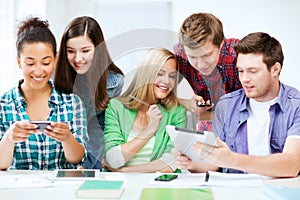 Students looking at smartphones and tablet pc