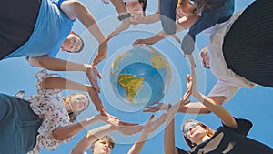 Students make a circle around the globe of the world. The concept of world peace.