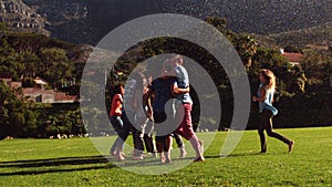 Students messing around in the sprinklers on the grass