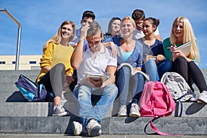 Students outside sitting on steps