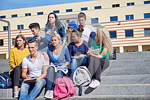 Students outside sitting on steps