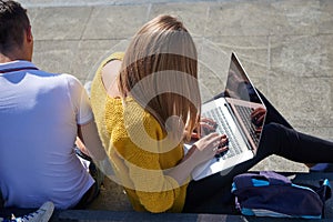 Students outside sitting on steps