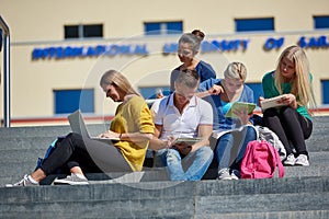 Students outside sitting on steps