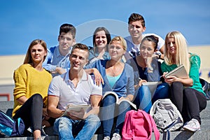 Students outside sitting on steps