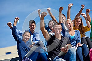 Students outside sitting on steps