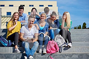 Students outside sitting on steps