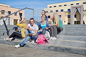 Students outside sitting on steps