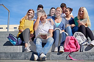 Students outside sitting on steps