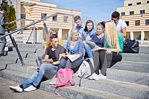 Students outside sitting on steps