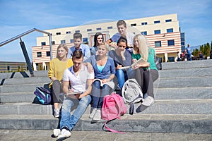 Students outside sitting on steps