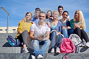 Students outside sitting on steps