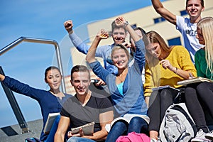 Students outside sitting on steps