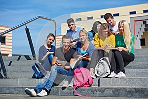 Students outside sitting on steps